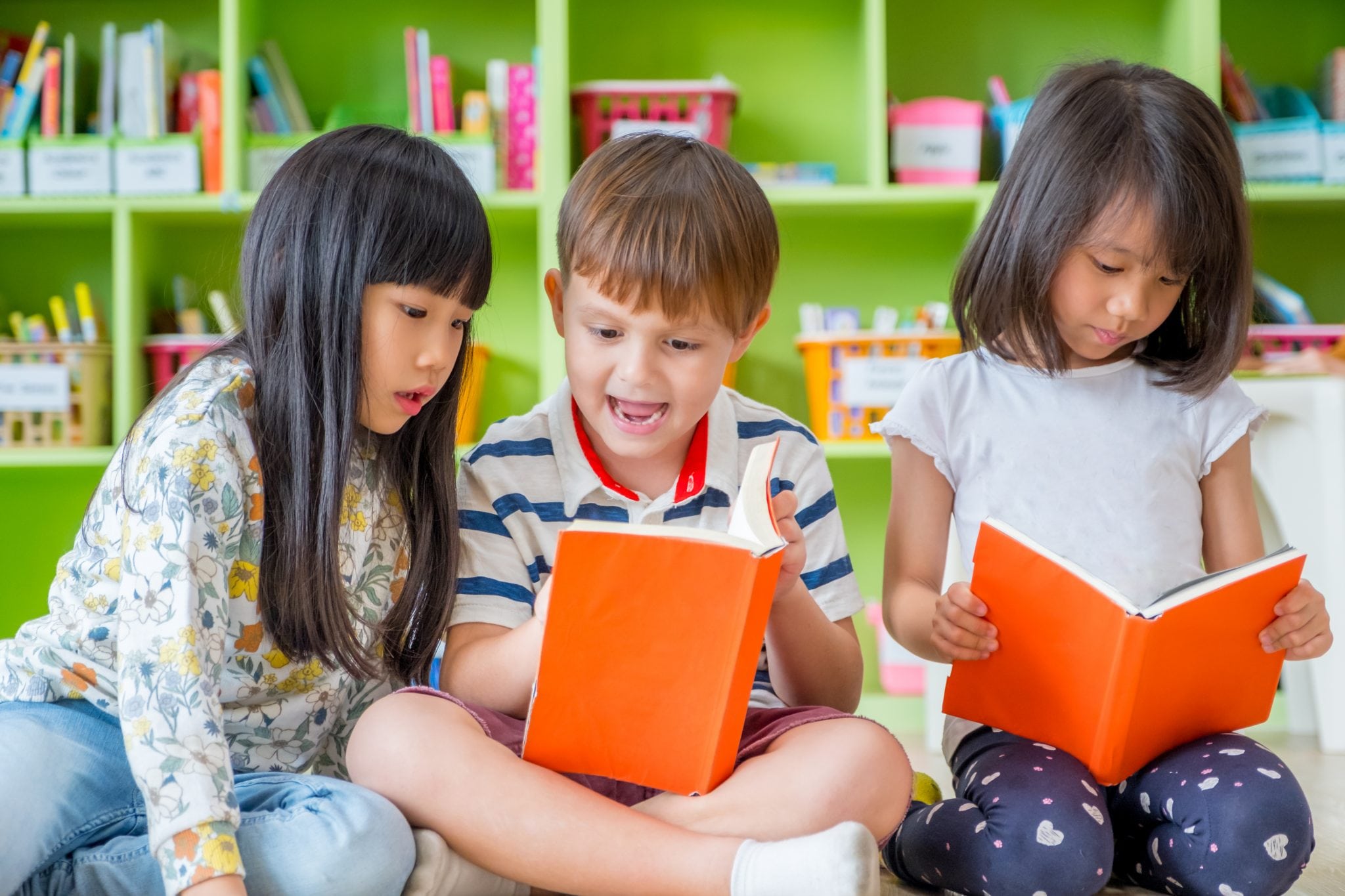 Children-sitting-on-floor-and-reading-tale-book-in-preschool-libraryKindergarten-school-education-concept.-859996890_3869x2580-copy
